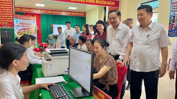 Các đại biểu tham quan, trải nghiệm thực tế hoạt động của tổ công nghệ số cộng đồng tại điểm hỗ trợ chuyển đổi số ở thôn Gián Khẩu. (Ảnh: YẾN TRINH)