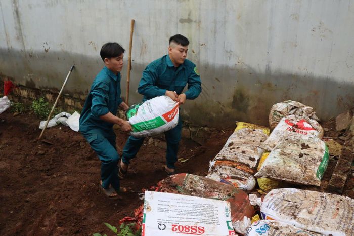  Khuân vác bao đất để làm mương, ngăn nước chảy vào khu dân cư. Ảnh: HỮU PHÚC 