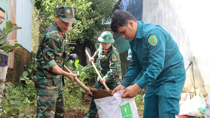  Cán bộ chiến sĩ xúc đất vào bao để gia cố. Ảnh: HỮU PHÚC 