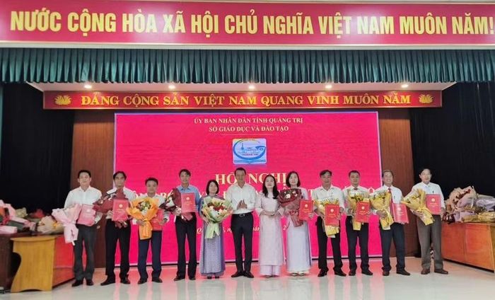 Bà Lê Thị Hương, Giám đốc Sở GD&ĐT và ông Võ Văn Minh, Phó Giám đốc Sở GD&ĐT trao quyết định và chúc mừng 10 Hiệu trưởng sau sắp xếp.