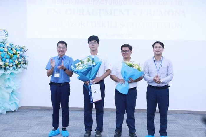 Đại diện của Đại học Phenikaa và Đại học Công nghiệp Hà Nội tặng hoa động viên hai thí sinh.