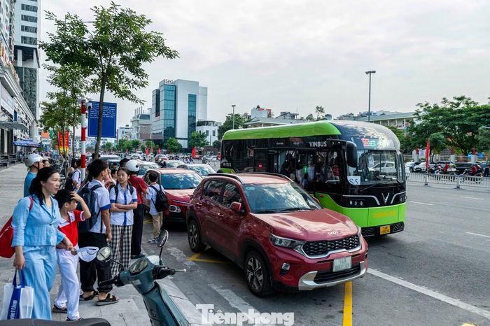 Tại điểm đón trước chung cư Lideco Trần Hưng Đạo, phường Hồng Gai, xe buýt phải dừng ra làn ngoài nơi nhiều phương tiện đang di chuyển để đón học sinh do bị chiếc xe con màu đỏ đỗ chiếm lối vào. Học sinh phải chen vào những khe hẹp hoặc đi xuống lòng đường để lên xe gây tiềm ẩn mất an toàn giao thông.
