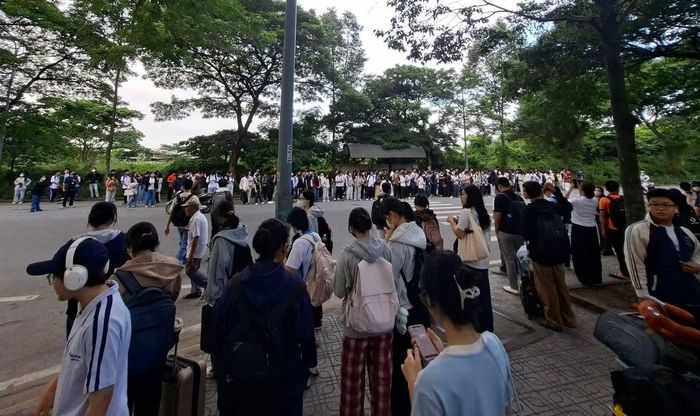 6 giờ 20 phút sáng, sinh viên ở ký túc xá khu B xếp hàng chờ xe buýt kín 2 bên đường. Ảnh: T.Đạt