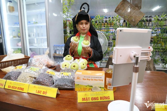 Bà Nguyễn Thúy Hà giới thiệu đặc sản địa phương tại gian hàng chuyển đổi số chợ Hạ Long 1. Ảnh: Phạm Công