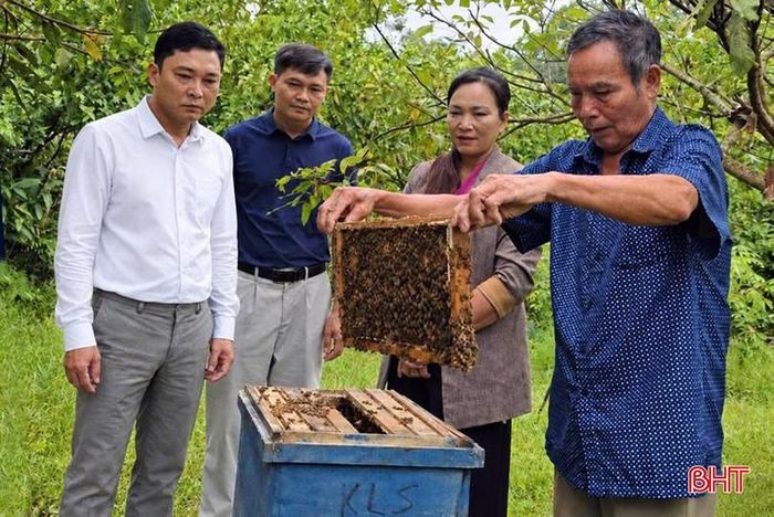 Cán bộ làm công tác giảm nghèo thôn và xã thăm mô hình nuôi ong của gia đình ông Nguyễn Thái Tuyển.