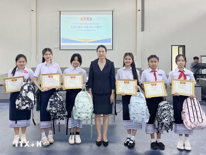 Bà Đặng Thị Hải Tâm, Tổng lãnh sự Việt Nam tại tỉnh Savannakhet trao bằng khen cho các học sinh đoạt giải Cuộc thi vòng Chung kết Em yêu tiếng Việt. (Ảnh TTXVN phát)