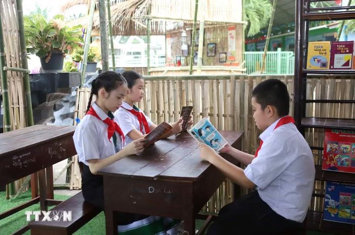 Học sinh hào hứng tìm hiểu về sách tiếng Việt tại Lễ Tôn vinh tiếng Việt tại Lào ở Trường Song ngữ Lào – Việt Nam Nguyễn Du ở thủ đô Vientiane. (Ảnh: Xuân Tú/TTXVN)