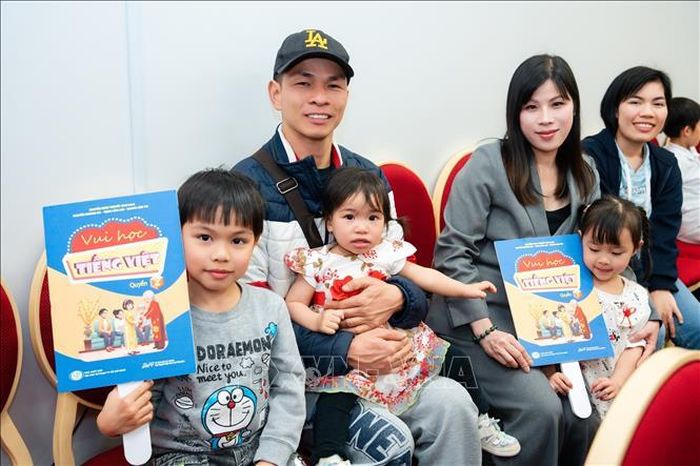 Các gia đình Việt Nam tại Kyushu hào hứng nhận bộ sách “Vui học tiếng Việt”. Ảnh: Nguyễn Tuyến/PV TTXVN tại Nhật Bản