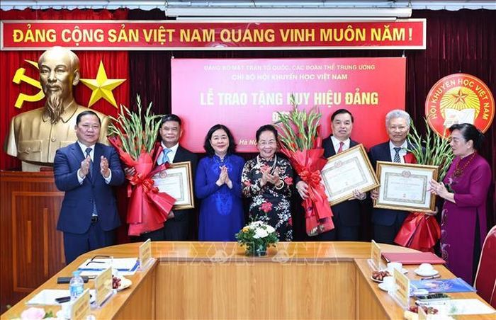 Đồng chí Bùi Thị Minh Hoài, Ủy viên Bộ Chính trị, Bí thư Trung ương Đảng, Chủ tịch Ủy ban Trung ương MTTQ Việt Nam trao tặng Huy hiệu 35 năm tuổi Đảng cho các cán bộ Hội Khuyến học Việt Nam. Ảnh: Minh Đức/TTXVN