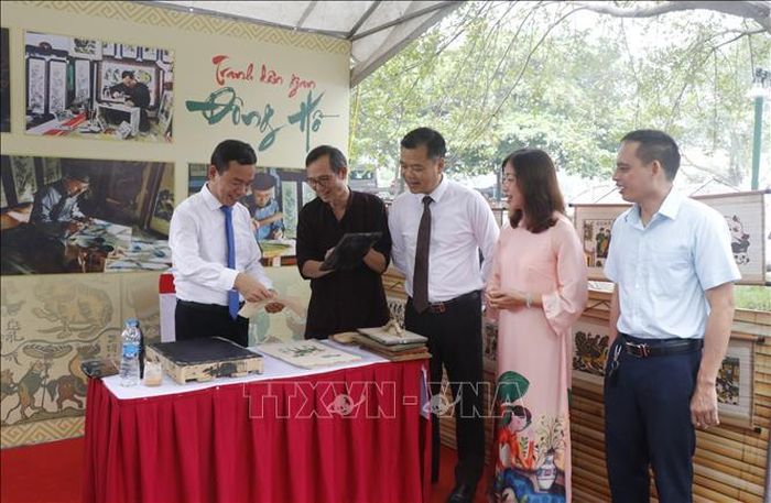Du khách hào hứng trải nghiệm in tranh dân gian Đông Hồ tại cụm di tích đình, chùa Đồng Kỵ, phường Đồng Nguyên, tỉnh Bắc Ninh.