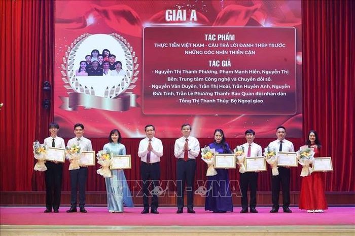 PGS.TS Đoàn Minh Huấn, Uỷ viên Bộ Chính trị, Giám đốc Học viện Chính trị quốc gia Hồ Chí Minh, Phó Trưởng Ban Chỉ đạo 35 Trung ương, Trưởng Ban Chỉ đạo Cuộc thi và đồng chí Nguyễn Long Hải, Ủy viên Trung ương Đảng, Phó Bí thư Thường trực Đảng ủy các cơ quan Đảng Trung ương trao giải A cho các tác giả, nhóm tác giả có tác phẩm đạt giải. Ảnh: Văn Điệp/TTXVN