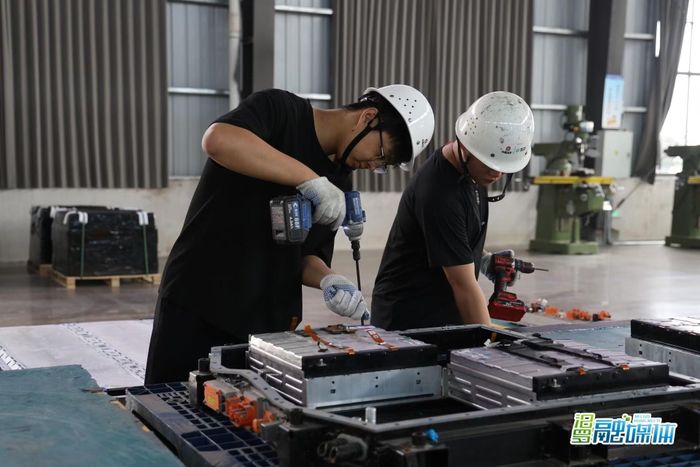 Công nhân tháo dỡ pin cũ theo quy trình xử lý. Ảnh: Xinmin.