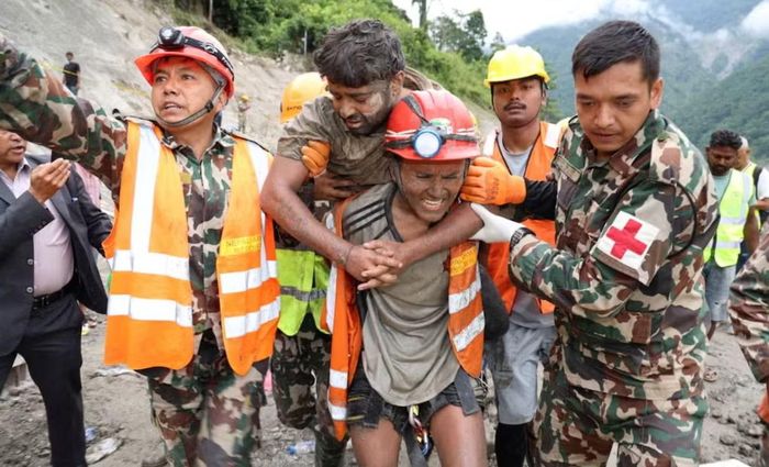 Sanjay Sah được các thành viên đội tìm kiếm và cứu hộ khiêng đi sau khi là một trong hai người được cứu sống khỏi một đường hầm tại Dự án thủy điện Trishuli-3A, nơi hai người khác bị mắc kẹt sau trận lũ lụt và sạt lở đất tàn khốc xảy ra trên sông Bhotekoshi ở Rasuwa, Nepal, ngày 4/9. Ảnh: Reuters.