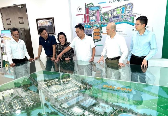 Doanh nhân Nguyễn Hoài Bắc (thứ 3 bên phải) đang giới thiệu cho khách tham quan mô hình của khu đô thị Đại Sơn do ông làm chủ đầu tư. Ảnh: TTXVN phát