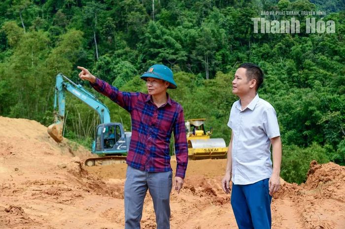 Chủ tịch UBND xã Sơn Điện Phạm Văn Tình (bên trái) chỉ đạo các đơn vị liên quan khẩn trương làm mặt bằng, bàn giao đất cho người dân xây dựng nhà ở kiên cố.