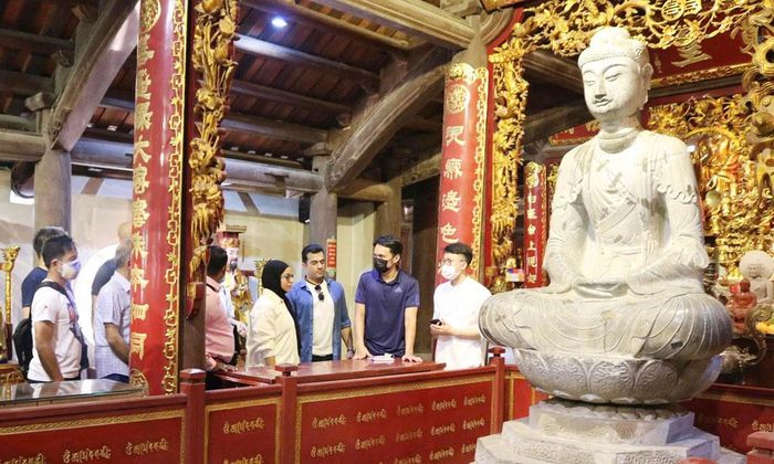 Du khách chiêm ngưỡng tượng Phật A Di Đà chùa Phật Tích. Ảnh: Trần Thảo.