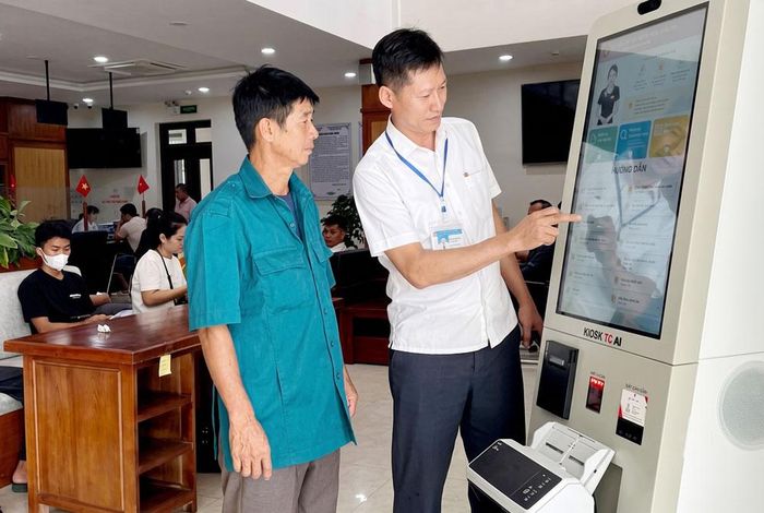  Cán bộ Trung tâm Hành chính công xã Lạng Giang hướng dẫn người dân thực hiện thủ tục hành chính tại Kiosk AI. 