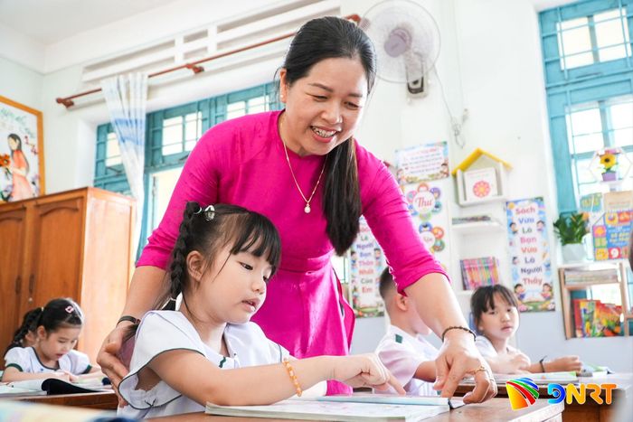 Cô giáo Ngô Thị Nguyên Thục, Phân hiệu 1 – Trường Tiểu học Tam Kỳ (phường Tam Kỳ) cho học sinh làm quen với những trang sách đầu tiên. Ảnh: HỒ QUÂN