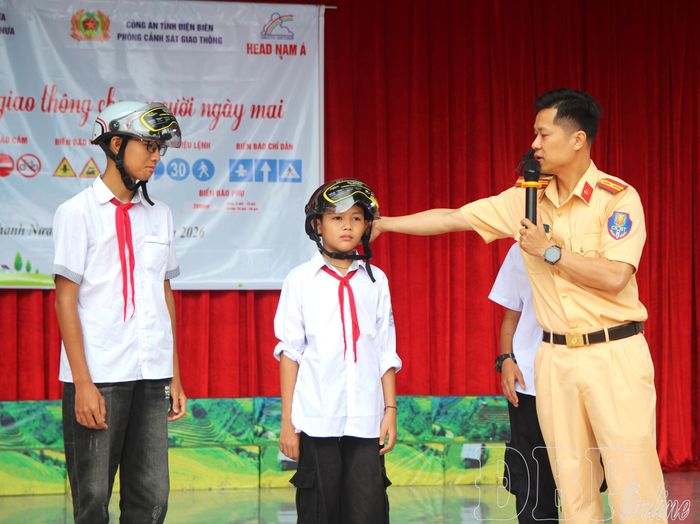 Cán bộ Phòng CSGT hướng dẫn học sinh đội mũ bảo hiểm đúng quy định. 