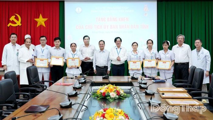 Giáo sư, Tiến sĩ, Bác sĩ Tạ Văn Trầm, Giám đốc Bệnh viện Đa khoa Tiền Giang (đứng thứ 6 bên phải), trao tặng Giấy khen cho các cá nhân.
