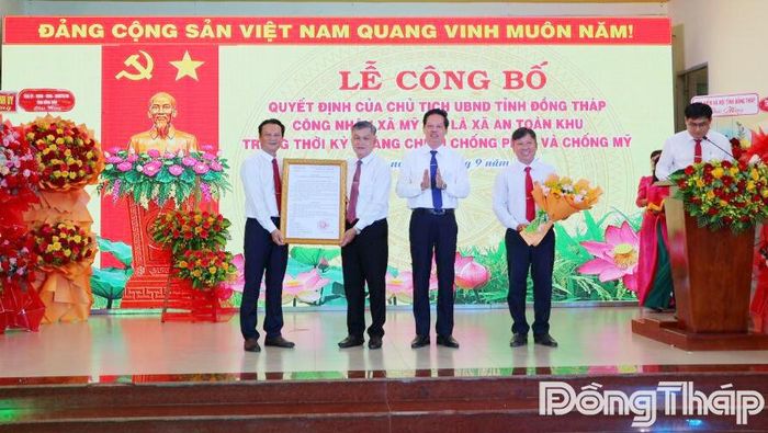 Đồng chí Nguyễn Thành Diệu (thứ 3 từ trái sang) trao Quyết định, tặng hoa chúc mừng lãnh đạo xã Mỹ Quí. 