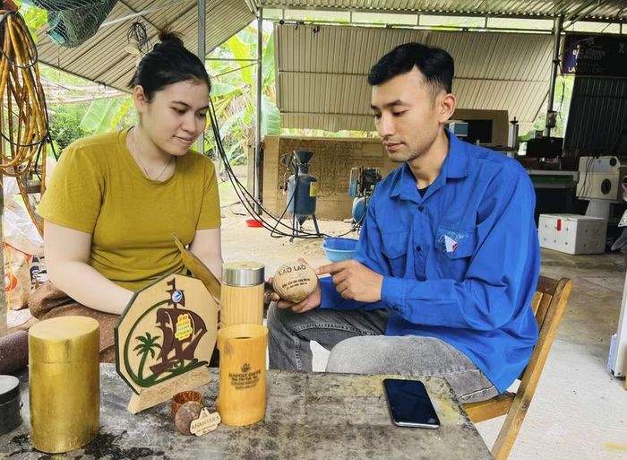  Anh Nguyễn Đắc Đợi (bìa phải) chia sẻ về những sản phẩm quà lưu niệm được làm từ quả dừa và tre. Ảnh: P.L 