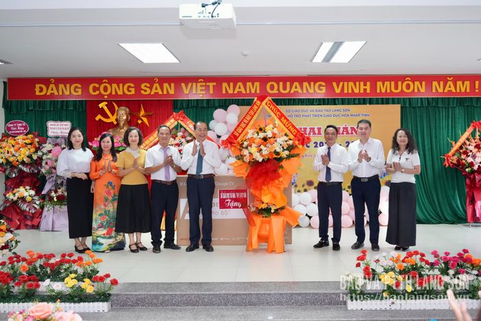 Đại diện Trung tâm Hỗ trợ phát triển gáo dục hoà nhập tỉnh nhận quà và hoa chúc mừng của Sở Giáo dục và Đào tạo