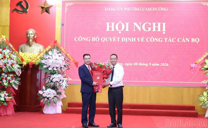 Đồng chí Vũ Hùng Dũng - Bí thư Đảng ủy phường Cam Đường trao quyết định và chúc mừng ông Nguyễn Viết Hiến.