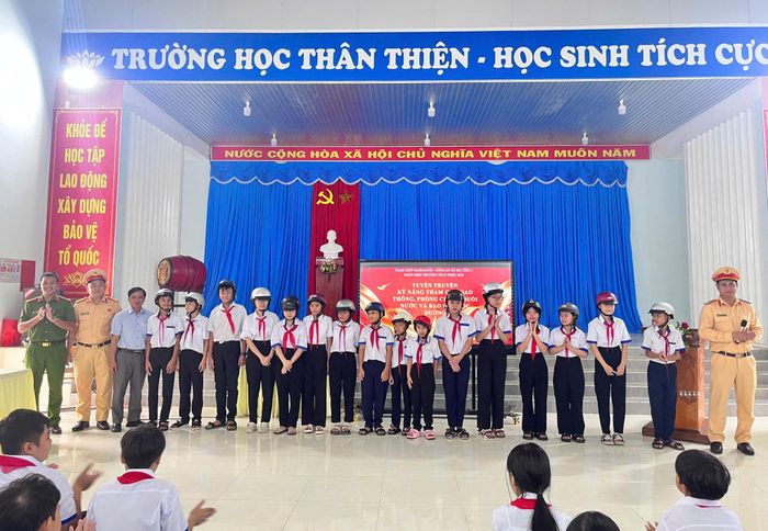 Lực lượng chức năng trao tặng mũ bảo hiểm cho học sinh Phân trường Triệu Hải. Ảnh Lê Tiến