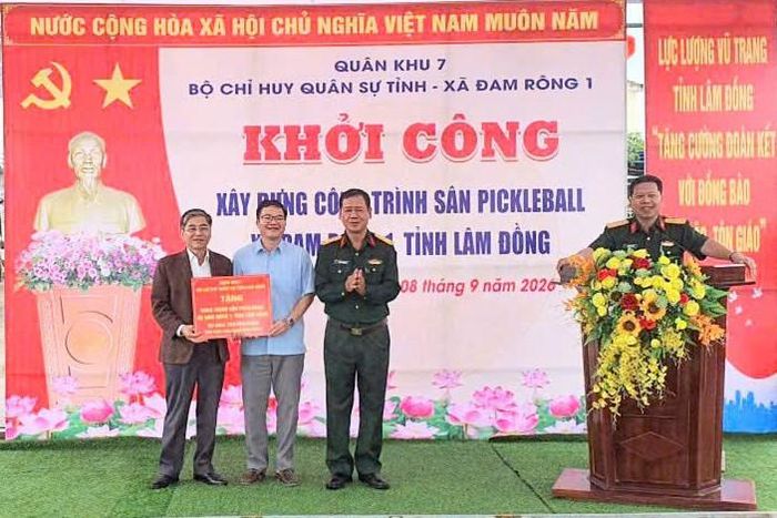 Đại tá Đinh Hồng Quân, Phó Chính ủy Bộ CHQS tỉnh Lâm Đồng trao biểu trưng hỗ trợ cho lãnh đạo xã Đam Rông 1
