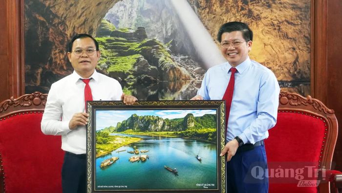 Đồng chí Trần Vũ Khiêm, Phó Bí thư Thường trực Tỉnh ủy, Trưởng đoàn đại biểu Quốc hội tỉnh trao quà lưu niệm cho đoàn công tác UBKT, Thanh tra Nhà nước tỉnh Sạ-vẳn-na-khệt - Ảnh: N.M