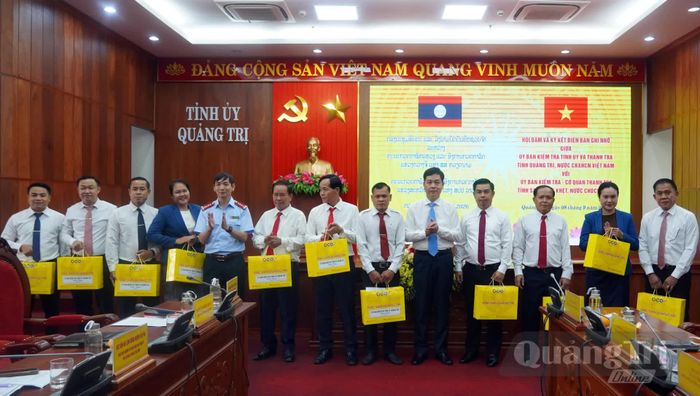 Đại diện lãnh đạo UBKT Tỉnh ủy Quảng Trị tặng quà các thành viên đoàn công tác - Ảnh: N.M