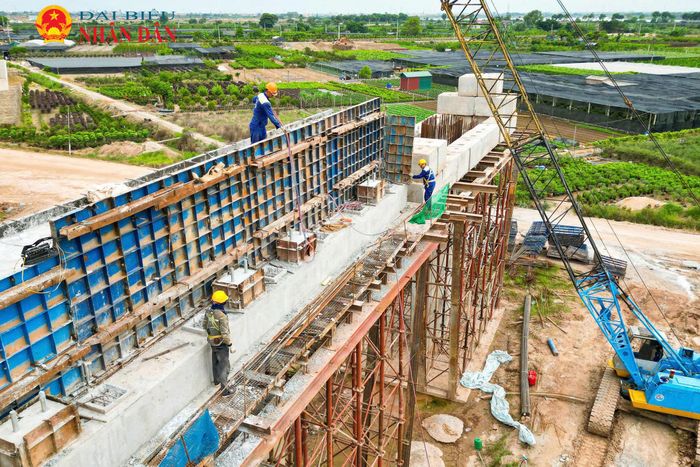 Dọc hai đầu cầu thuộc địa phận Hà Nội và Hưng Yên, không khí lao động khẩn trương bao trùm khi hàng trăm công nhân cùng hệ thống máy móc hạng nặng đang bám trụ, thi công liên tục