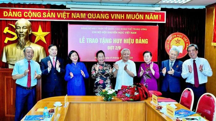 Các đại biểu, đảng viên dự buổi lễ cùng chúc mừng các đảng viên lão thành nhận huy hiệu Đảng. 