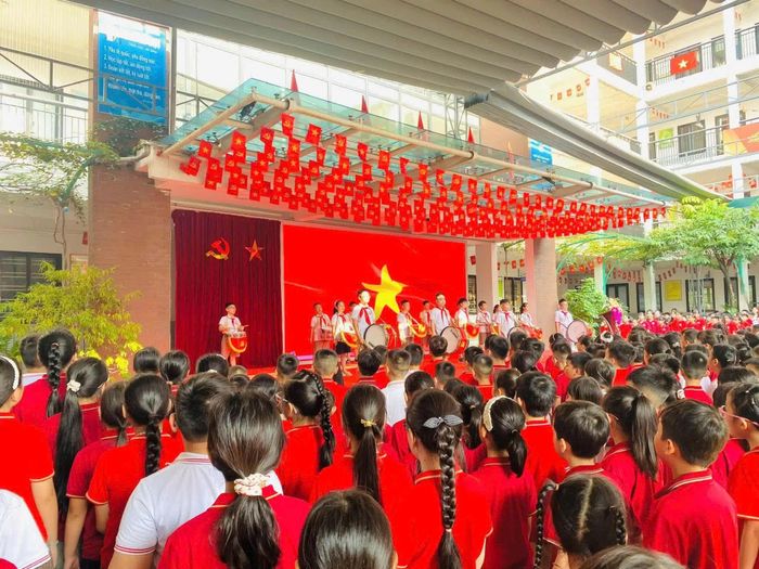 Học sinh thực hiện nghi thức chào cờ, cùng bắt đầu tuần học mới trong không khí vui tươi, phấn khởi.