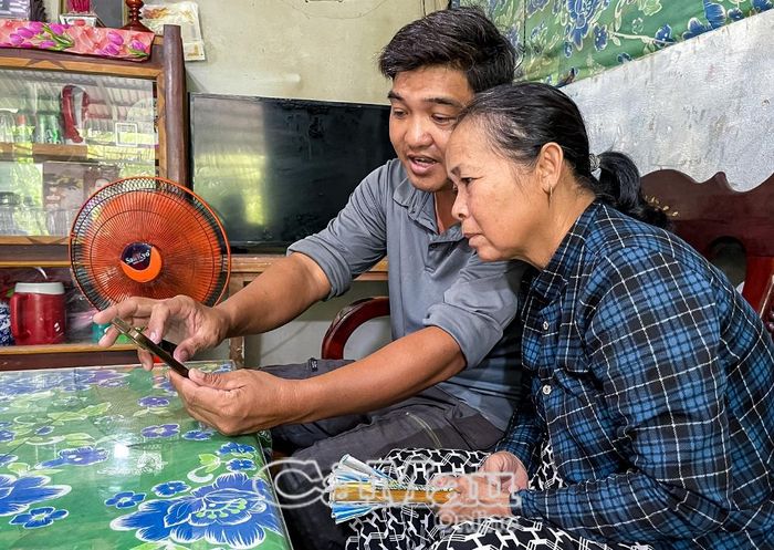 Anh Trần Bá Niên, Trưởng ban Công tác Mặt trận ấp Kênh Mới, hướng dẫn người dân tham gia các hội, nhóm số của ấp để nắm bắt thông tin, chính sách địa phương triển khai.