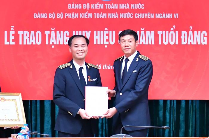 Ủy viên Ban Thường vụ Đảng ủy, Phó Tổng Kiểm toán nhà nước Doãn Anh Thơ trao Huy hiệu 30 năm tuổi Đảng cho Kiểm toán trưởng Trần Văn Hảo. Ảnh: N. Ly