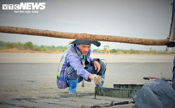 Giờ nghỉ trưa, những người thợ làm đường băng trên khuôn mặt vẫn bám đầy mồ hôi, tay vẫn còn vệt dính dầu máy, màu sơn và bụi bê tông.