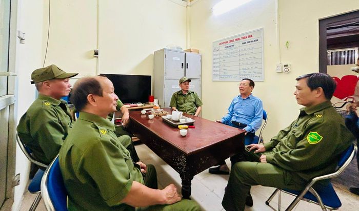 Ông Phạm Ngọc Quế (áo xanh), Trưởng ban Công tác Mặt trận Tổ dân phố số 13, trao đổi công việc với các thành viên Tổ An ninh cơ sở. Ảnh: Trần Oanh
