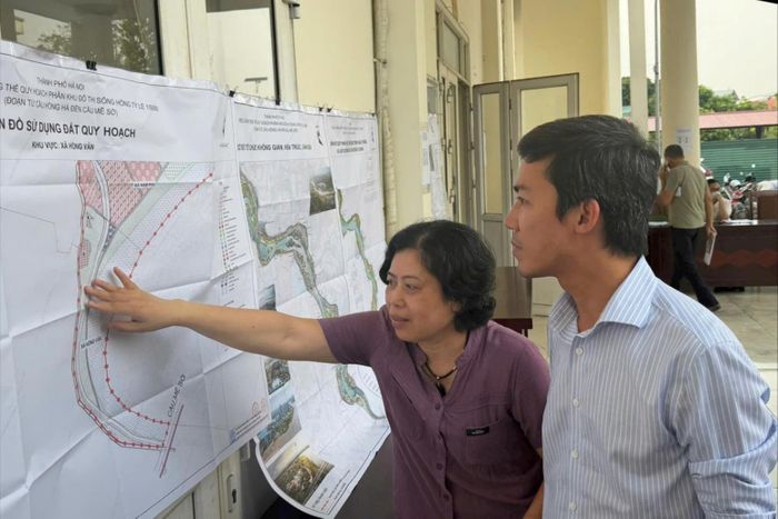 Bà Lê Thị Hà, xã Hồng Vân cùng người dân xem bản đồ quy hoạch. Ảnh: Thu Phương