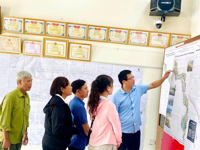 Người dân xã Ô Diên trực tiếp tìm hiểu bản đồ quy hoạch, quan tâm đến hướng tuyến và những khu vực có thể chịu tác động của dự án. Ảnh: Đỗ Duẩn