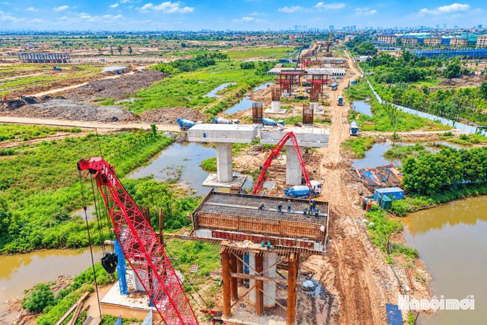 Cầu chính vượt sông Hồng dài khoảng 680m, rộng 38,3m, đáp ứng 6 làn xe cơ giới và 2 làn xe hỗn hợp. Cầu dẫn dài khoảng 6,58km, trong đó đoạn qua địa phận Hà Nội dài khoảng 5,4 km, đoạn qua Hưng Yên 2,1 km. Trong ảnh: Công nhân đang khẩn trương đổ bê tông, hoàn thiện các trụ cầu.