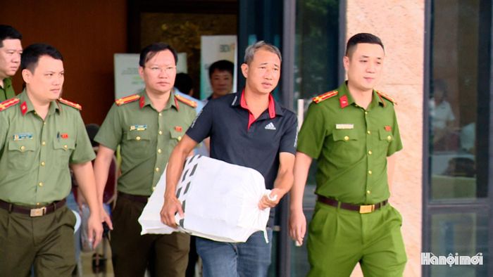 Công an phường hỗ trợ người dân di chuyển tiền về nhà. Ảnh: Lại Tấn