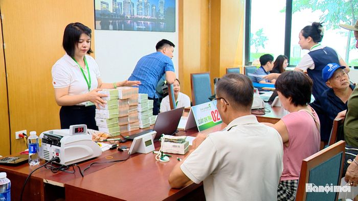 Nhân viên ngân hàng có mặt tại điểm chi trả để hỗ trợ người dân. Ảnh: Lại Tấn