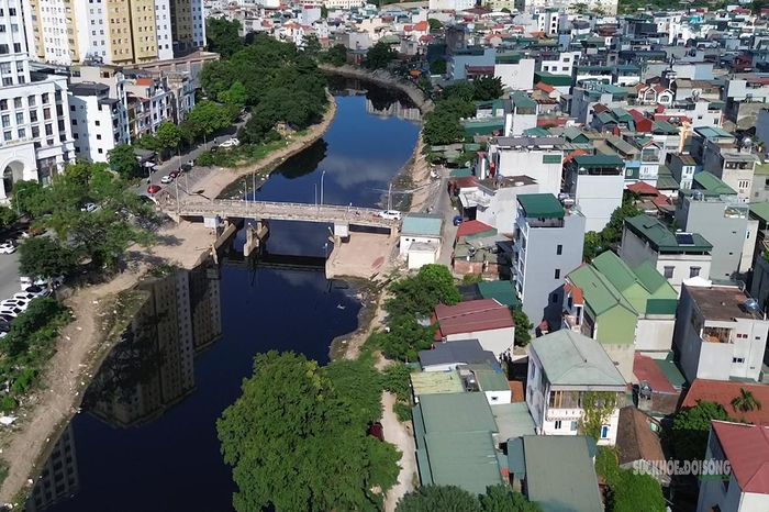 Một đoạn sông Nhuệ qua khu dân cư với mực nước thấp, màu nước sẫm. Ảnh: T.Anh