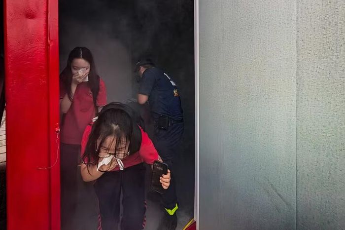 Ho sặc sụa, cúi gập người, tay che kín mũi miệng. Đó là phản xạ sinh tồn bản năng nhưng hoàn toàn chính xác khi các em vừa thoát ra khỏi căn buồng mô phỏng không gian ngập khói độc (khói huấn luyện)