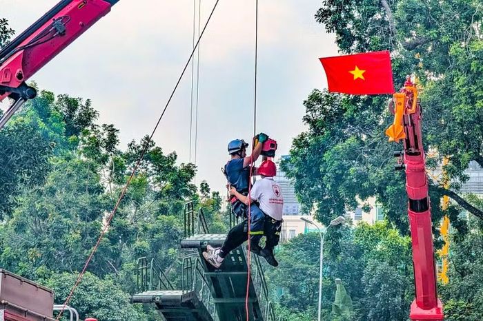 Ngước nhìn lên cao, lá cờ đỏ sao vàng tung bay cạnh cần cẩu thủy lực khổng lồ. Lính cứu hỏa ôm chặt "nạn nhân", đu dây tụt nhanh từ trên đỉnh tháp xuống đất trong tiếng vỗ tay rào rào của khán giả.