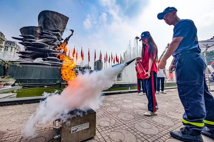Hơi nóng ngùn ngụt từ khay xăng bốc cháy. Một nữ sinh không hề nao núng, xách bình chữa cháy tiến sát, bóp cò nhả bọt trắng xóa khống chế ngọn lửa ngay...