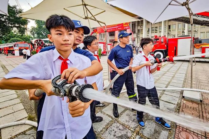 Sức giật của lăng phun bọt không làm khó được hai nam sinh. Dưới sự kẹp sát, hỗ trợ trụ vững của người lính PCCC và CNCH Công an Thủ đô, luồng nước áp lực cao đánh thẳng vào mục tiêu.
