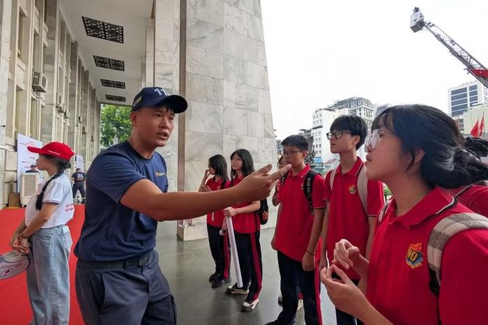 Trước khi bước vào "thực chiến", các em được quán triệt kỹ quy tắc an toàn. Ánh mắt chăm chú, tập trung cao độ của nhóm học sinh khi nghe chiến sĩ cứu hỏa phổ biến tình huống giả định.